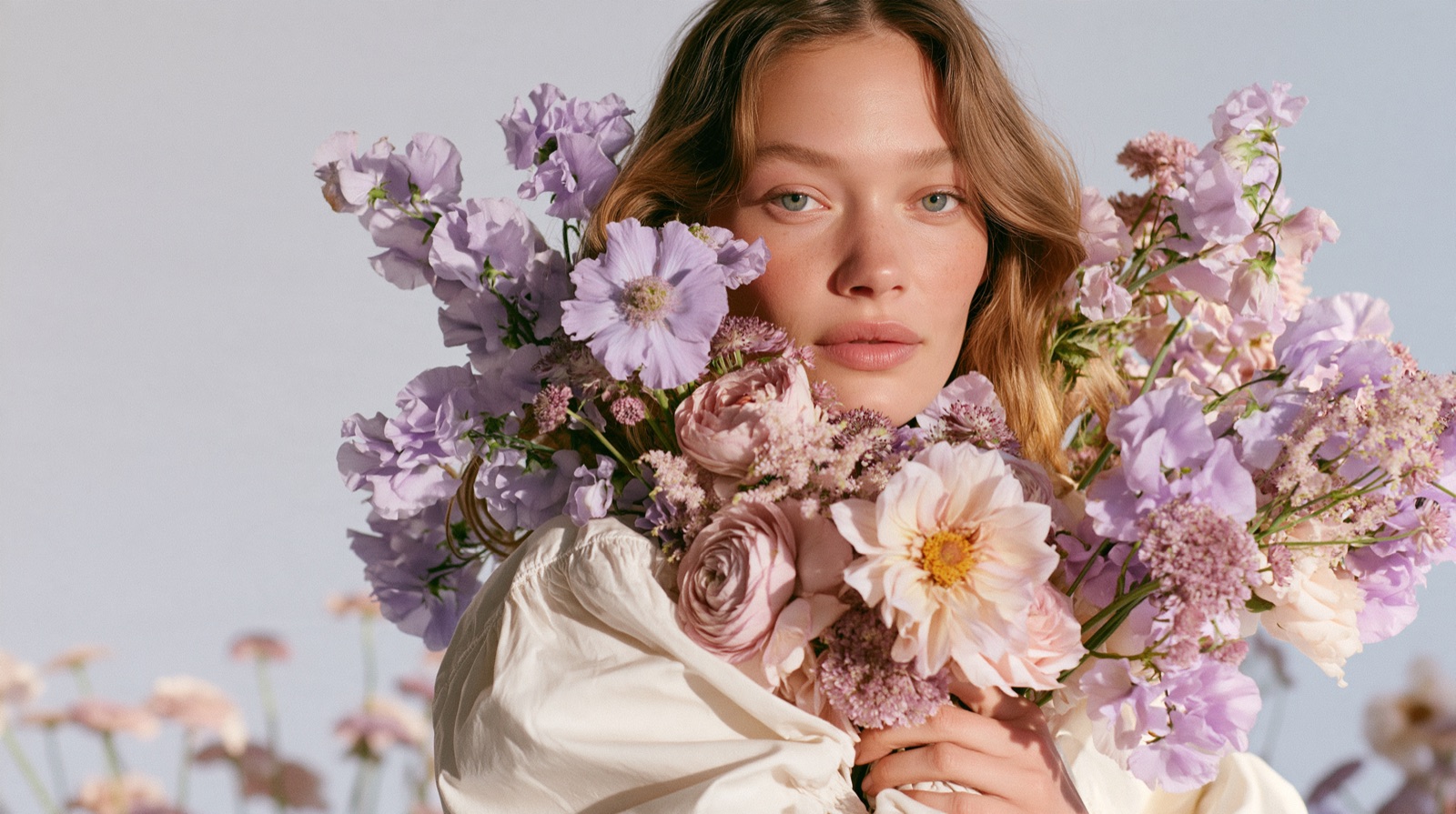 Woman holding a large bouquet of lilac and pink flowers